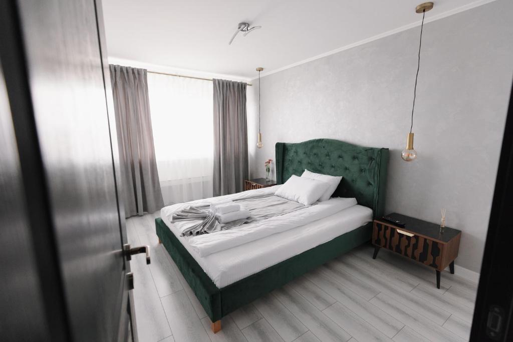 a bedroom with a bed with a green headboard at Bear's Apartment 2 Alba Iulia in Alba Iulia