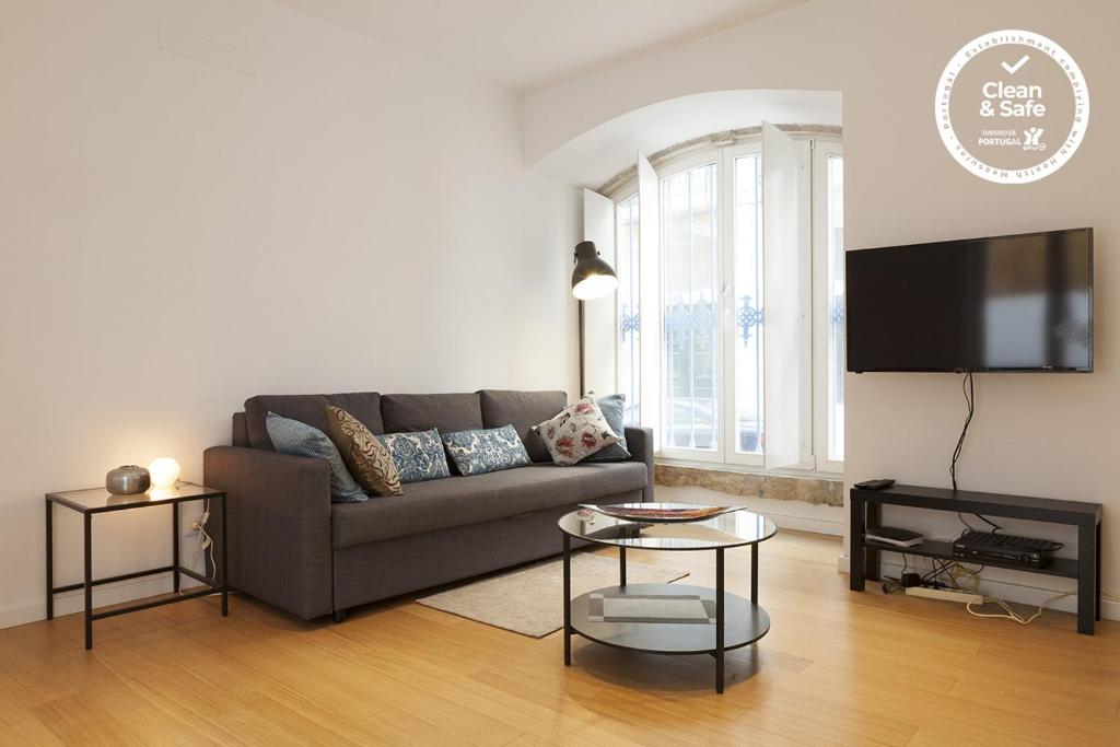 a living room with a couch and a flat screen tv at Downtown Blue Terrace by Homing in Lisbon