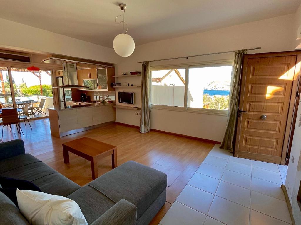 a living room with a couch and a table at Infinity view - Few steps away from the sea. in Agia Pelagia