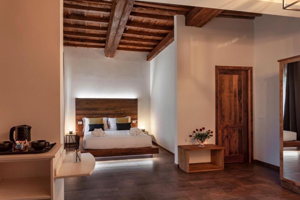 een slaapkamer met een groot bed met een houten hoofdeinde bij Oro Nero Florence in Florence