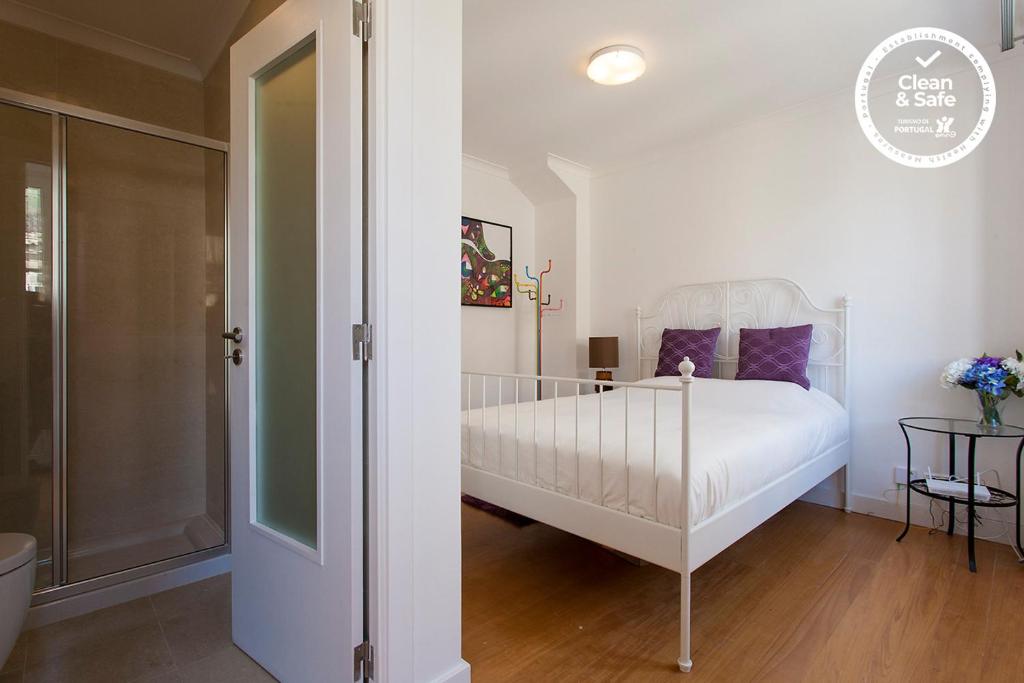 a bedroom with a white bed with purple pillows at Santa Justa Suites by Homing in Lisbon