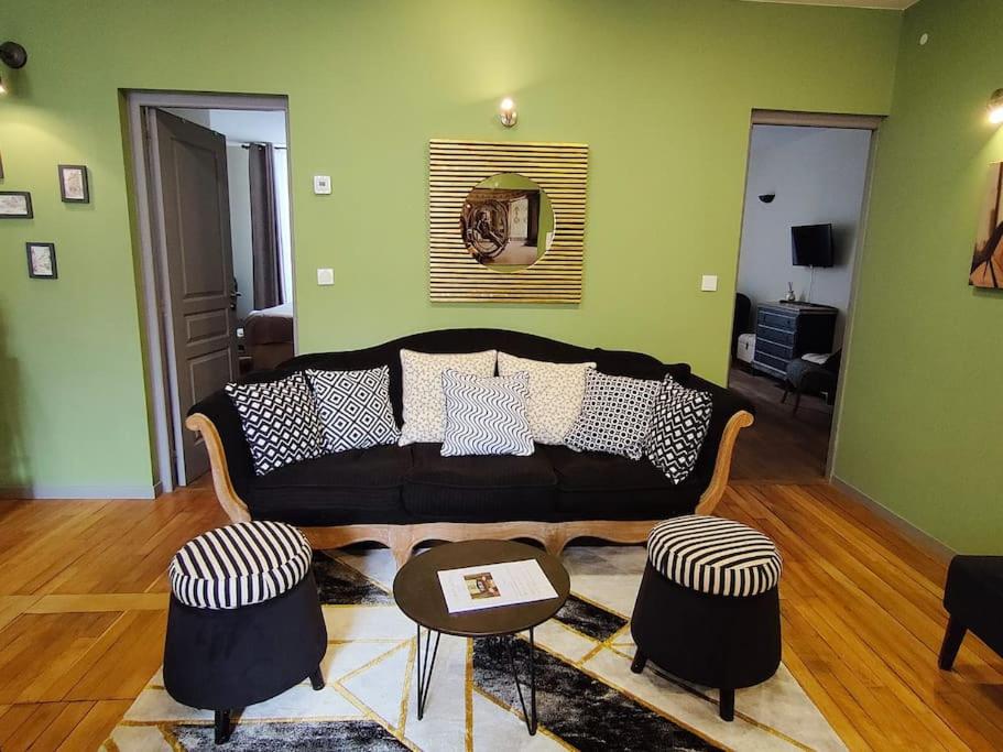 ein Wohnzimmer mit einem Sofa und 2 Hockern in der Unterkunft La Chouette des Ducs, Appartement en Hypercentre in Dijon
