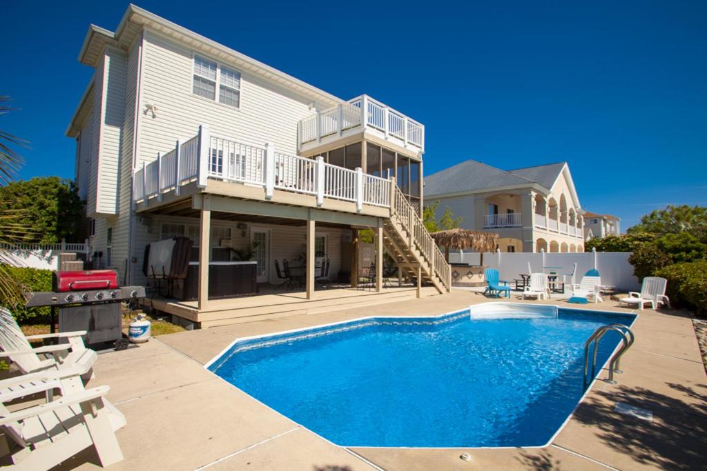 a house with a swimming pool in front of a house at A Slice of Paradise in Virginia Beach