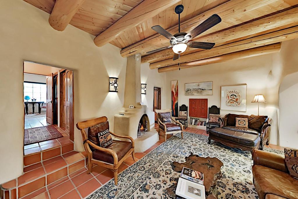 ein Wohnzimmer mit einem Deckenventilator und einem Kamin in der Unterkunft Alfred's Hacienda & Casita in Taos