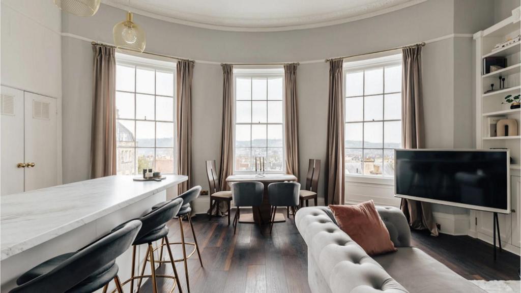 a living room with a couch and chairs and windows at The Portland Apartment - Georgian Building with parking in Bath