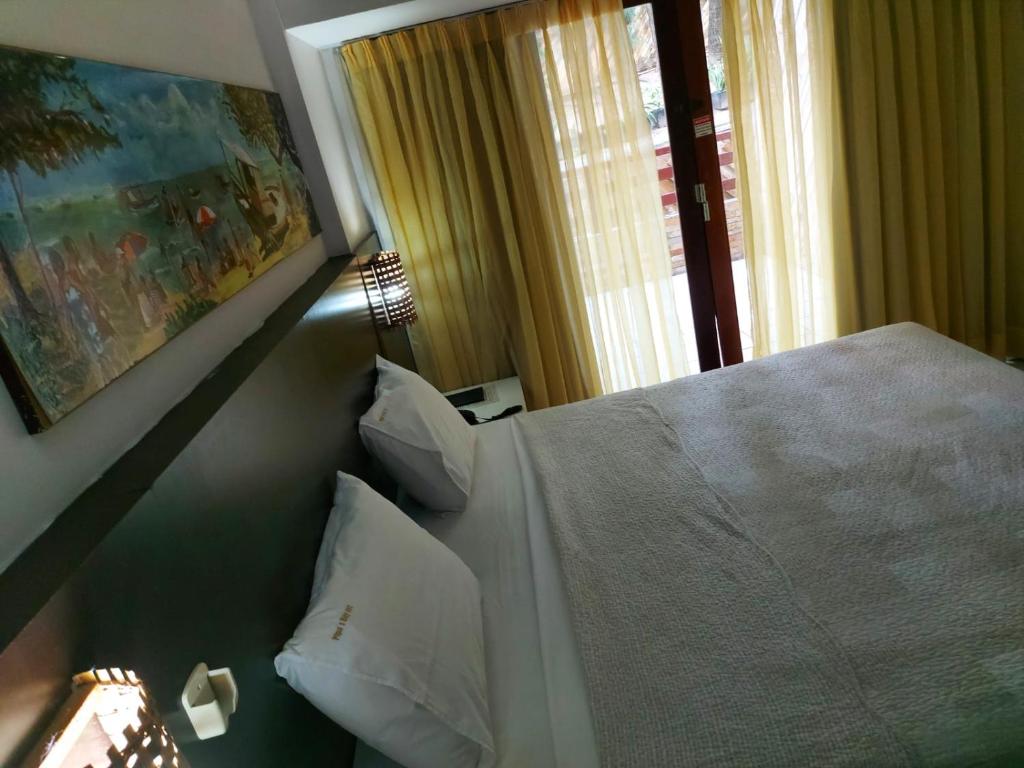1 dormitorio con 1 cama blanca y ventana en Flat Particular 111 no Pipas Bay, en Pipa