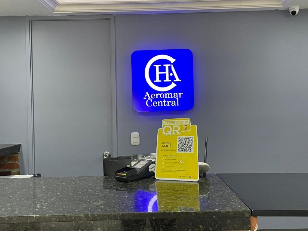 un panneau pour un terminal aéroportuaire avec un panneau jaune sur un comptoir dans l'établissement Hotel Aeromar Central, à Santa Marta