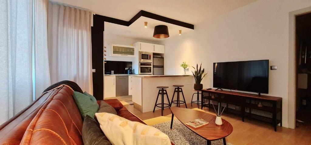 a living room with a couch and a tv and a kitchen at Apartamento Vacacional Lukita in Llanes