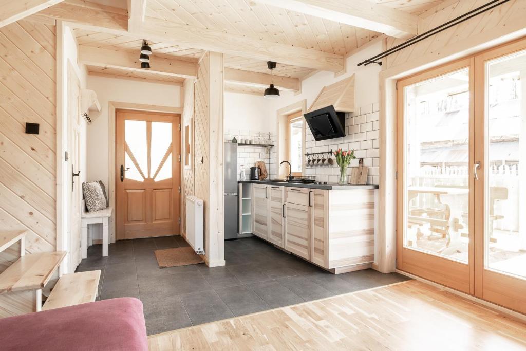 a kitchen with wooden walls and a wooden door at Dolina in Zakopane