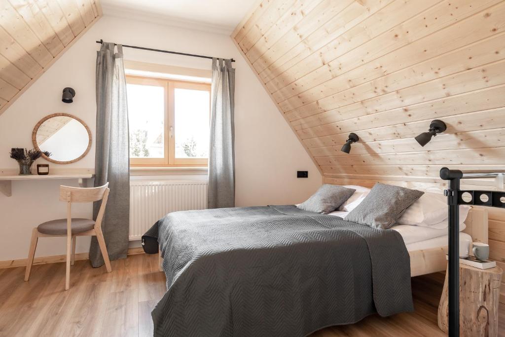 a bedroom with a bed and a wooden wall at Dolina in Zakopane