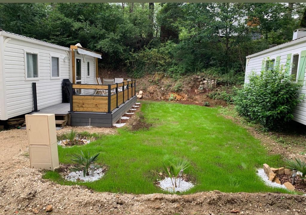 a yard with a house and a campsite with a yard at Les mobil homes d’oliver rob in Saint-Chéron
