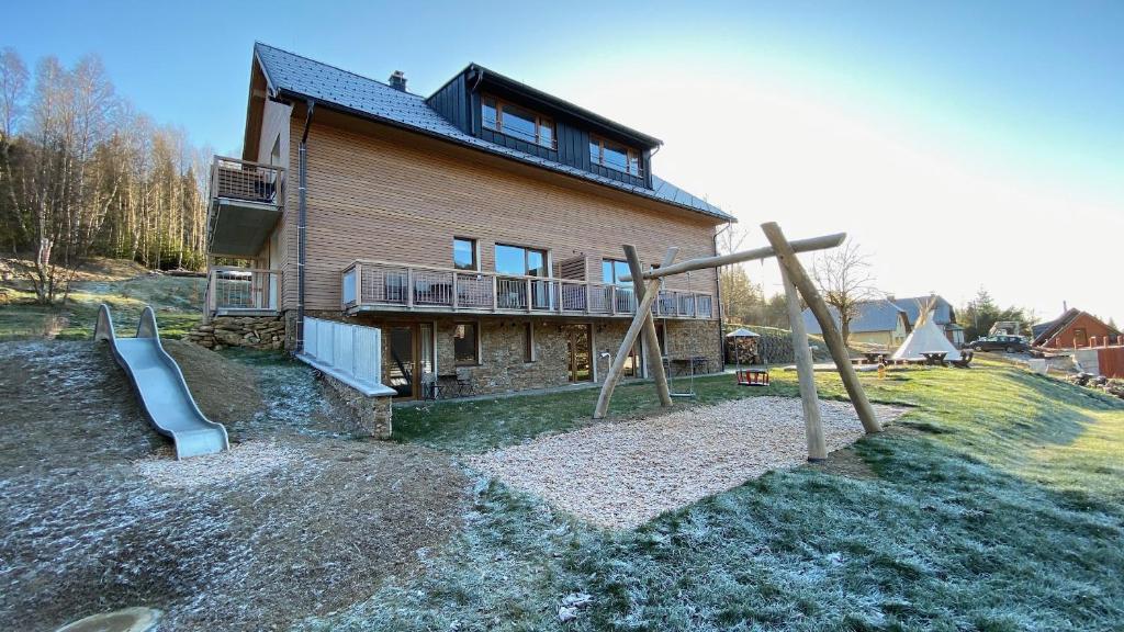 a house with a slide and a playground at Vetrnik Depandance Hotelu Jirinka in Dolní Morava