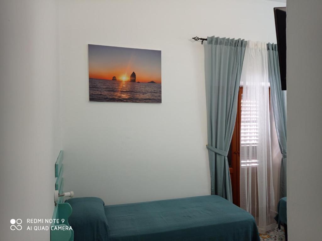1 dormitorio con 1 cama y una foto del océano en Casa Vacanze Central Cincotta, en Lipari