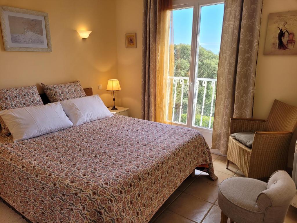 a bedroom with a bed and a window and a chair at Villa à Pinarello-2mn à pied de la plage-vue mer in Pinarellu