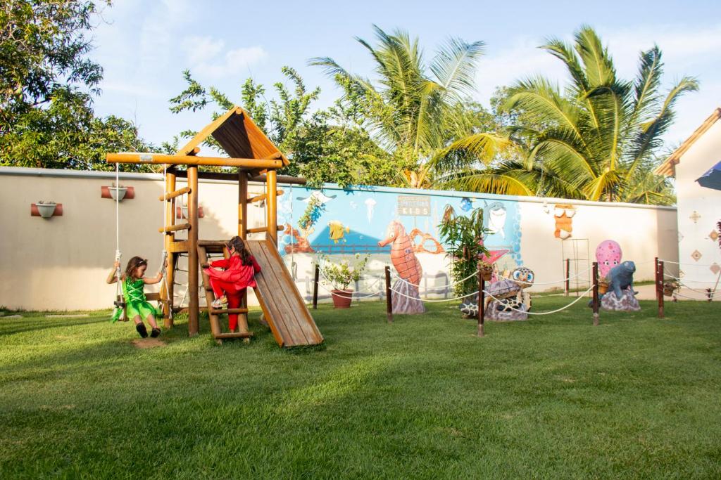 duas crianças a brincar num parque infantil num quintal em Pousada Polymar em Maragogi