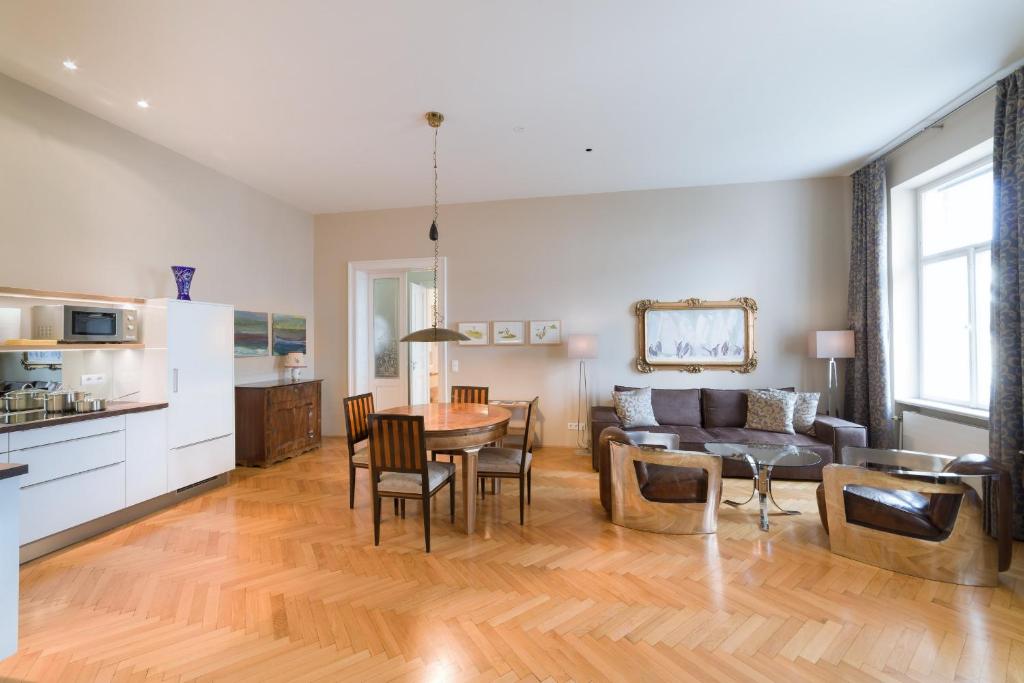 a kitchen and living room with a table and a couch at Sissi - Schoenbrunn-Living perfect Apartments in Vienna
