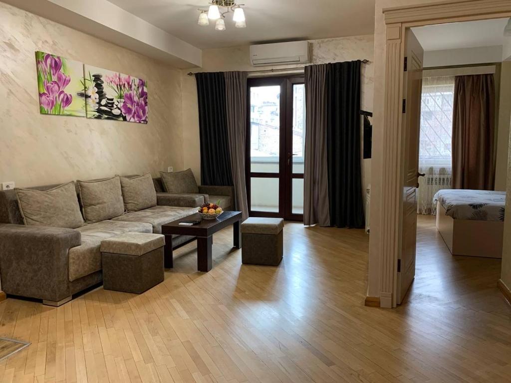 sala de estar con sofá y mesa en Comfortable apartment in center, en Ereván