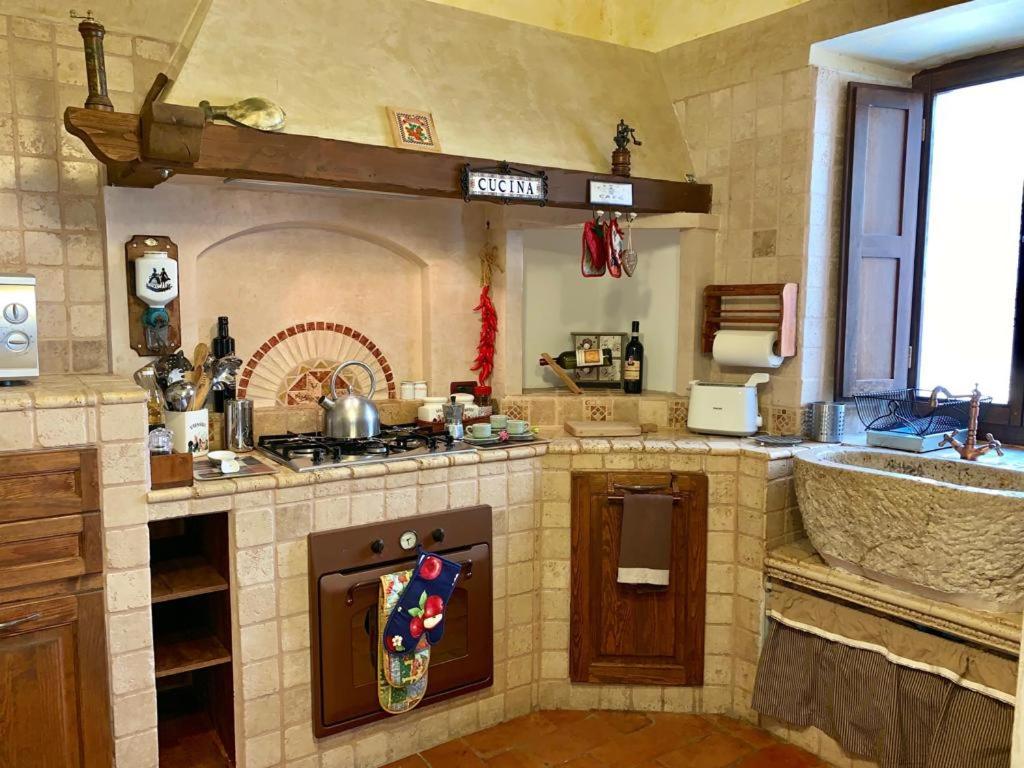 a large kitchen with a stove and a sink at Maidalchini House in Acquapendente