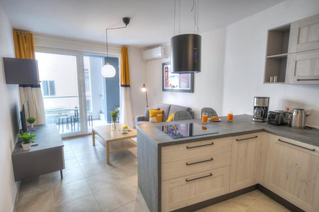 a kitchen and living room with a couch and a table at Bright and beautifully furnished apartment close to seafront BFRA1-2 in Il-Gżira
