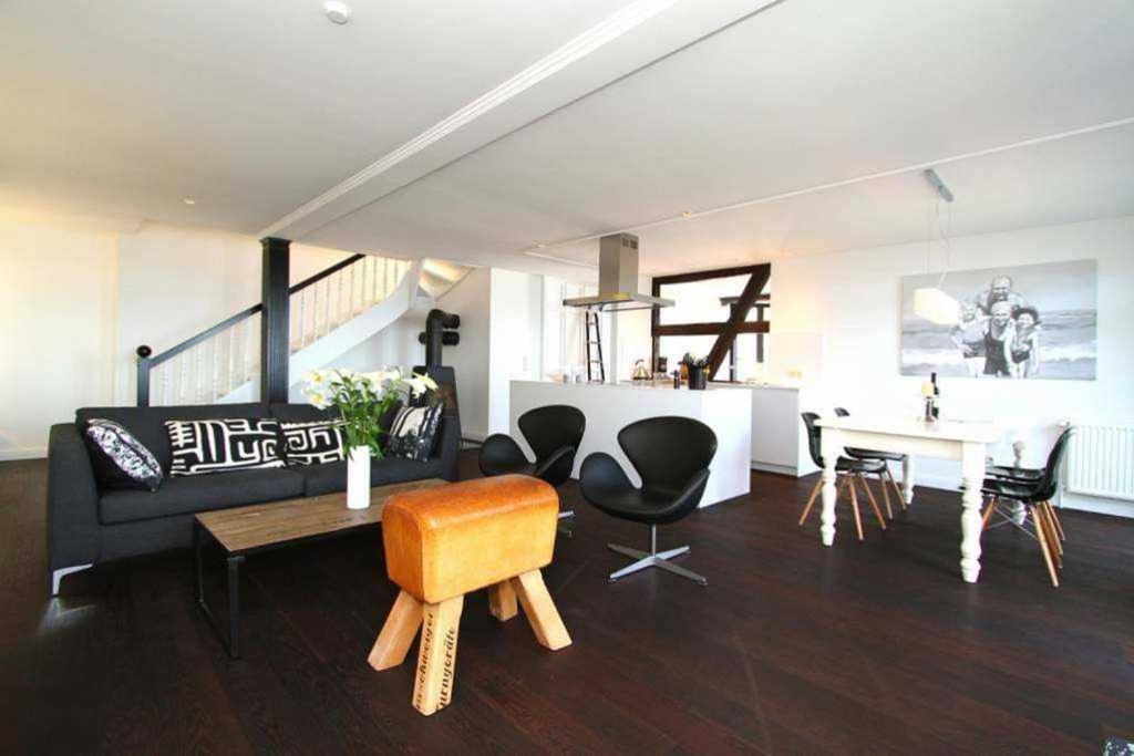 un soggiorno con divano, tavolo e sedie di Villa Schering App 4 Black White a Heringsdorf