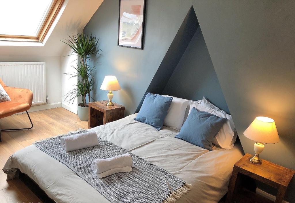 a bedroom with a large bed with blue pillows at Modern 3-bedrooms house with 6 guests in Sheffield