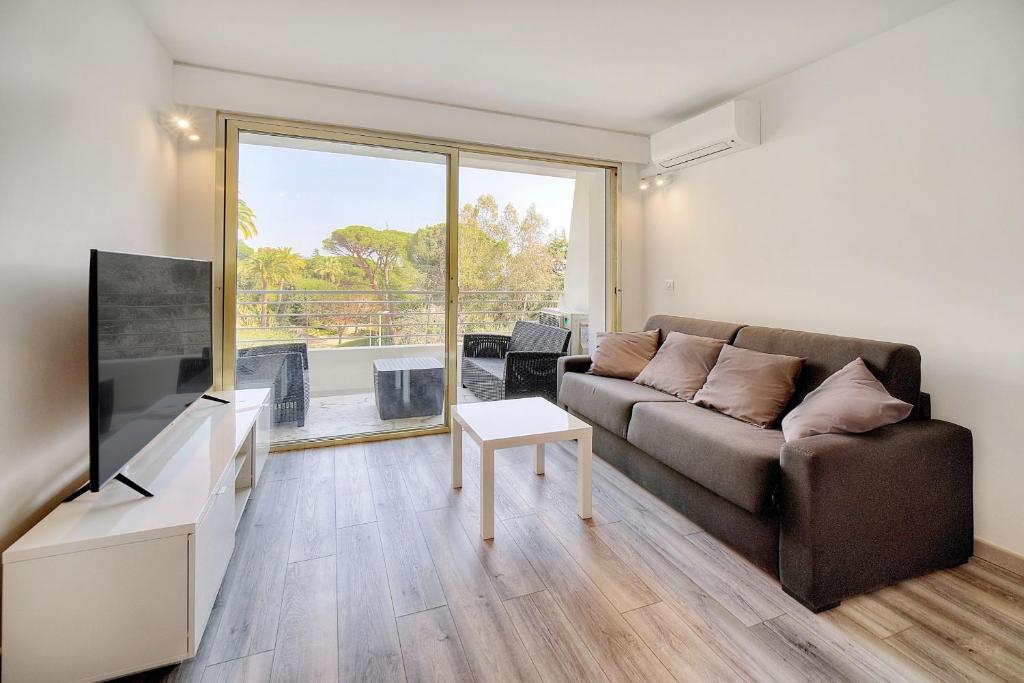 un salon avec un canapé et une télévision dans l'établissement IMMOGROOM - Pool - Terrace - Parking - Air conditioning - NO WIFI, à Cannes
