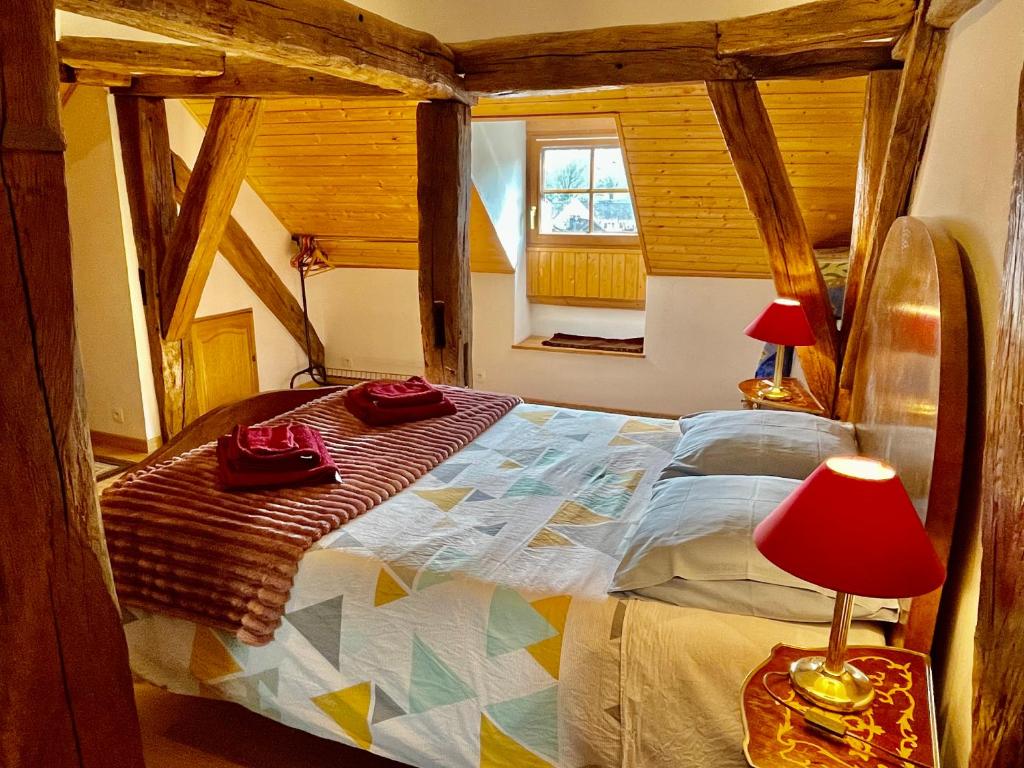 - une chambre avec un grand lit et une lampe rouge dans l'établissement Manoir Saint-Pierre, à Villersexel