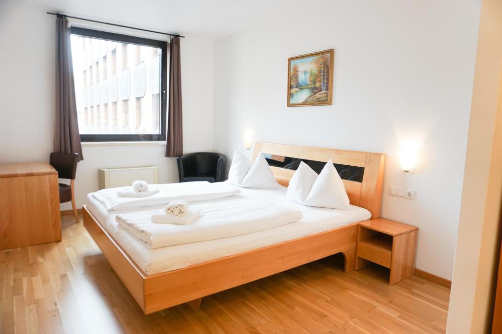 a bedroom with a bed with white sheets and a window at Hotel Kaffeemühle in Vienna