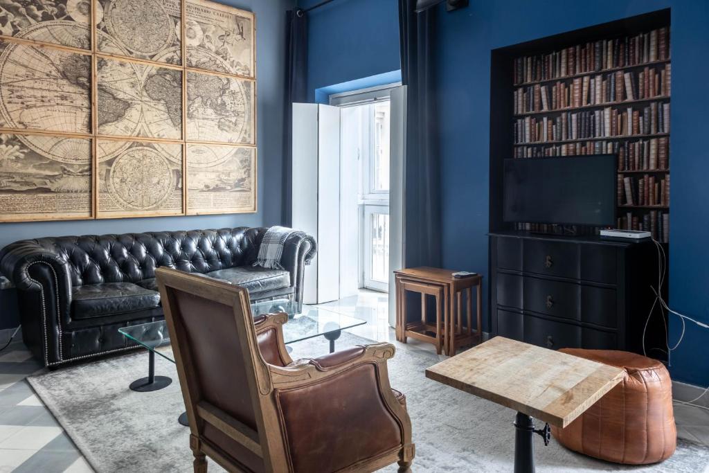 a living room with a leather couch and a tv at Blue Home by Cadiz Time in Cádiz