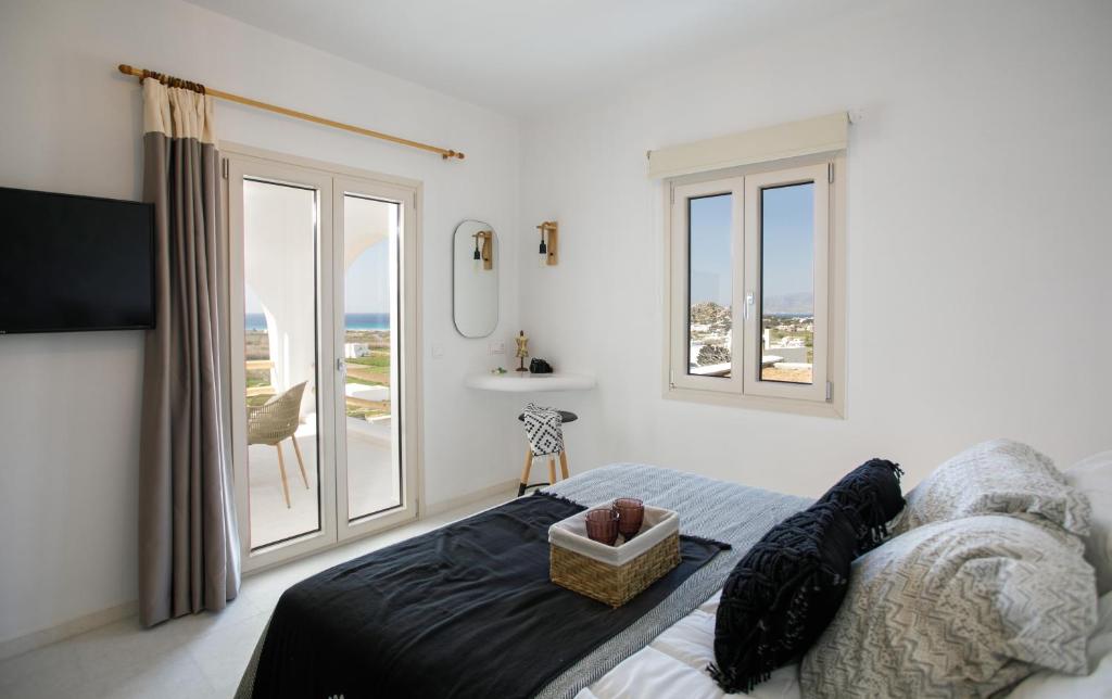 a bedroom with a bed with a view of the ocean at Naxos Earth Suites in Mikri Vigla