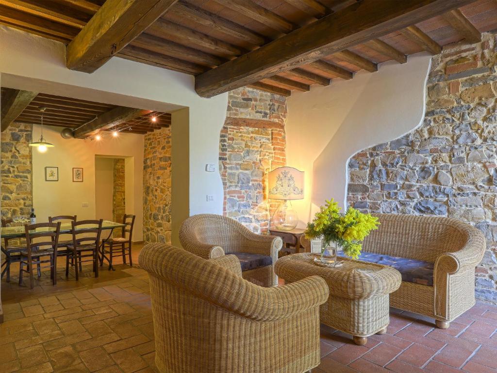 a living room with wicker furniture and a stone wall at Apartment Boccaccio by Interhome in San Donato in Poggio