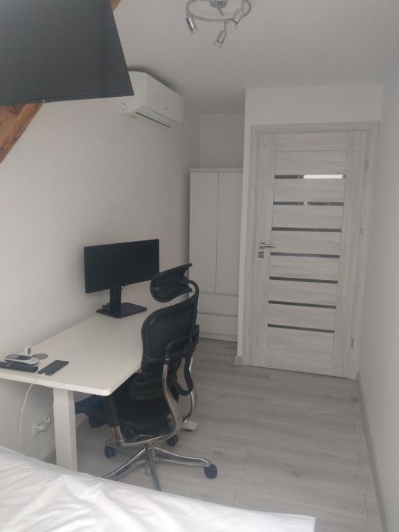 a bedroom with a desk with a computer and a bed at Sleep In Center in Kraków