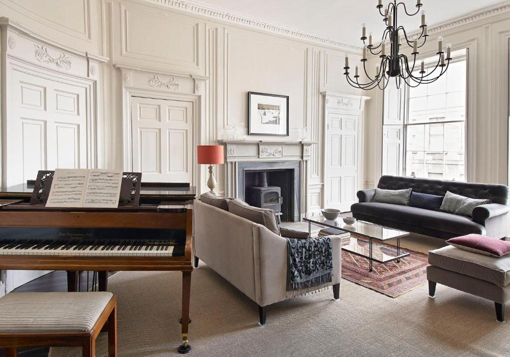 愛丁堡的住宿－The Art House at The New Town，客厅配有钢琴和沙发