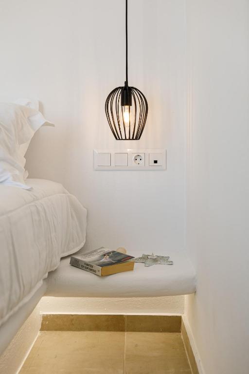 a bedroom with a bed and a table with a book at Naxos Earth Suites in Mikri Vigla