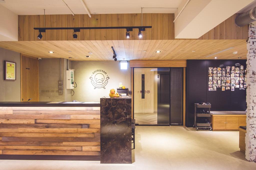 a bar in a restaurant with wooden walls at Ahiruyah Guesthouse in Kaohsiung
