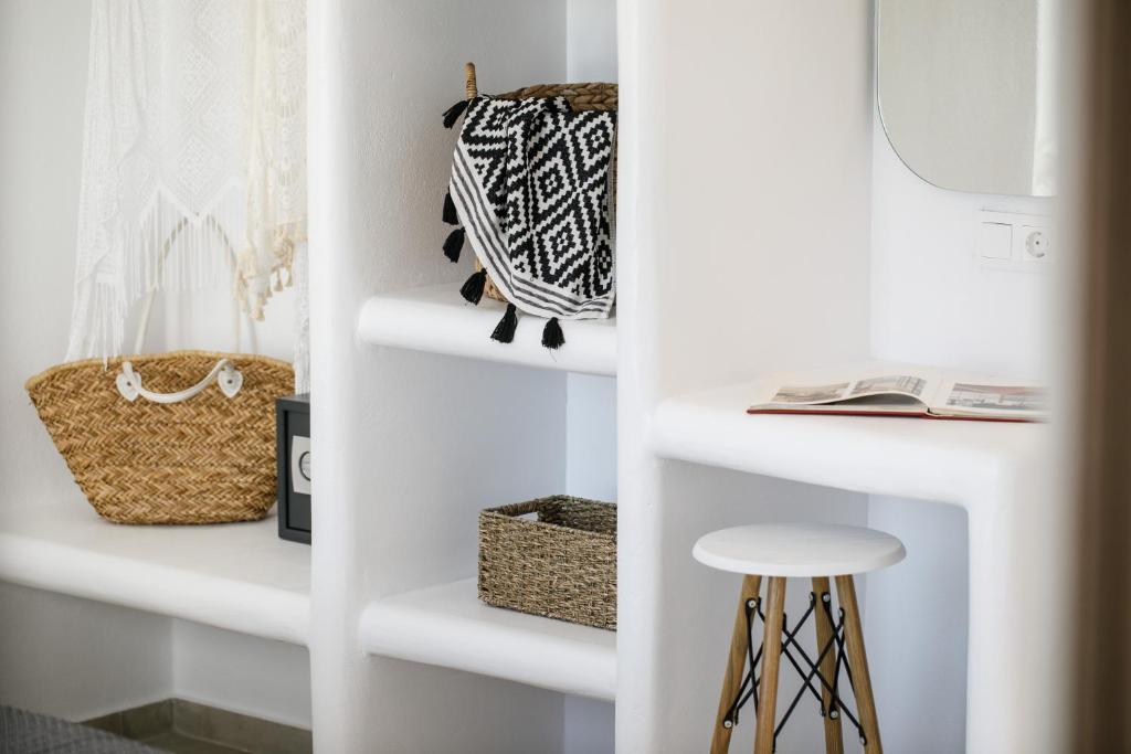 a white closet with white shelves and a stool at Naxos Earth Suites in Mikri Vigla
