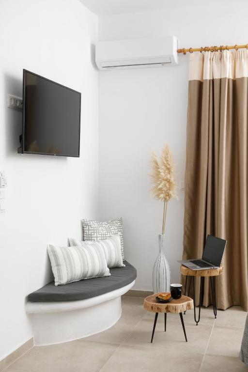 a living room with a couch and a tv at Naxos Earth Suites in Mikri Vigla