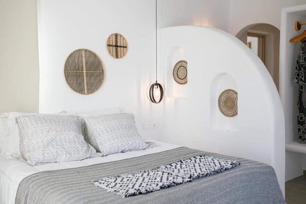 a bedroom with a bed with a white wall at Naxos Earth Suites in Mikri Vigla