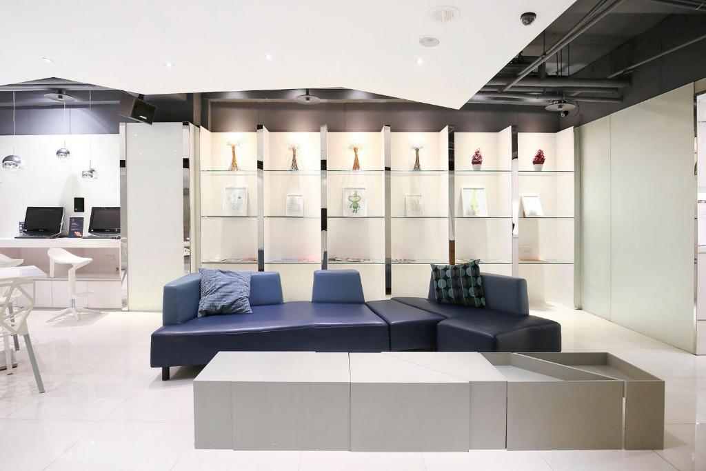 a living room with a blue couch and a table at CityInn Hotel Plus - Ximending Branch in Taipei