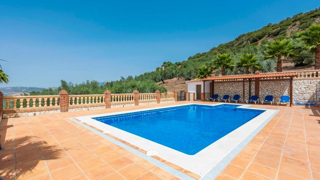 Finca Cerro Alcolea Periana by Ruralidays في Periana: مسبح في حديقه خلفيه مع سياج