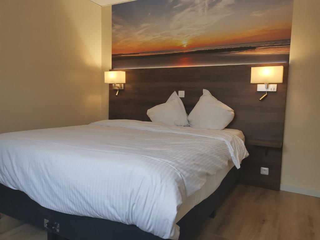 a bedroom with a large white bed with two pillows at Hotel Albert II Oostende in Ostend