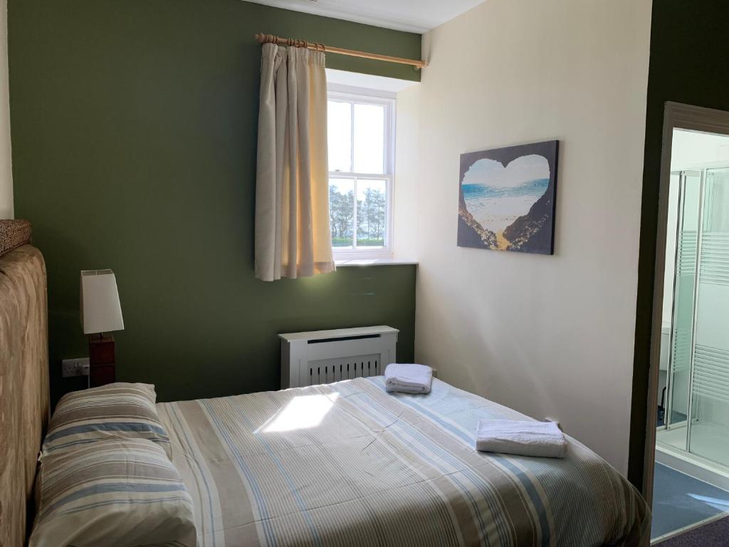 a bedroom with a bed and a window at Jersey Accommodation and Activity Centre in Gorey