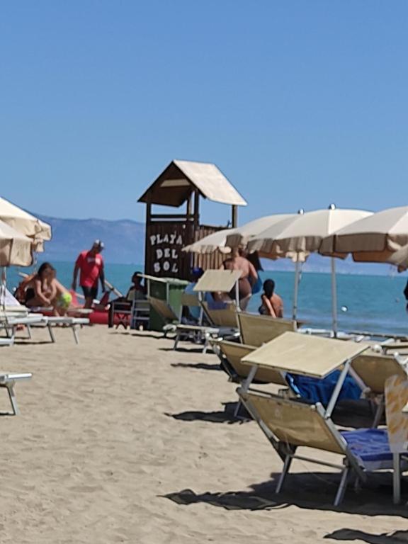 un grupo de sillas y sombrillas en una playa en Villa Lucia Anna, en Scalo dei Saraceni Manfredonia