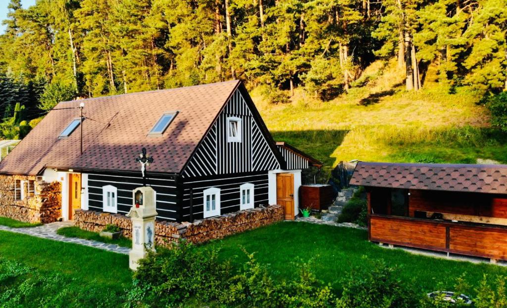 a black and white house with a stone wall at Roubenka 1818 in Všelibice