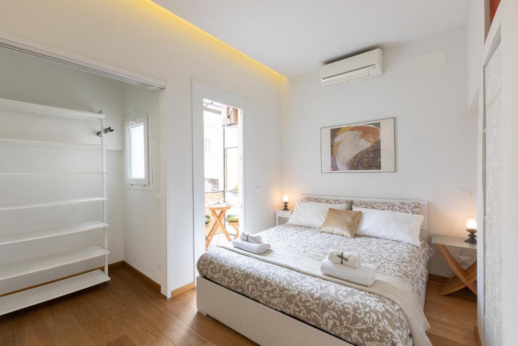 a white bedroom with a bed and a window at Trevi Rome Central House in Rome