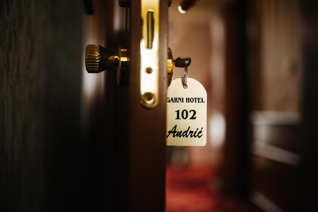 un pomo de puerta con una etiqueta pegada a él en Garni Hotel Andric en Sombor