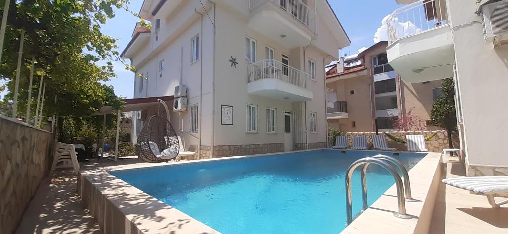 a swimming pool in front of a building at Mert Apart in Mugla