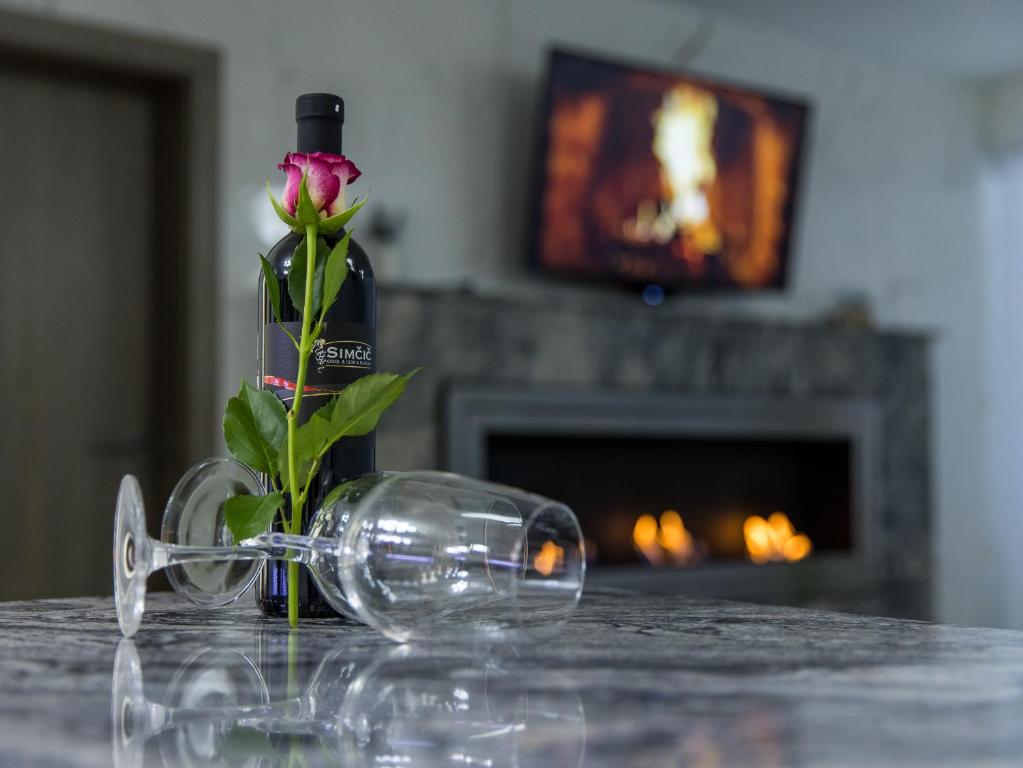 una botella de vino y una flor delante de una mesa en Reset Apartments, en Kranjska Gora