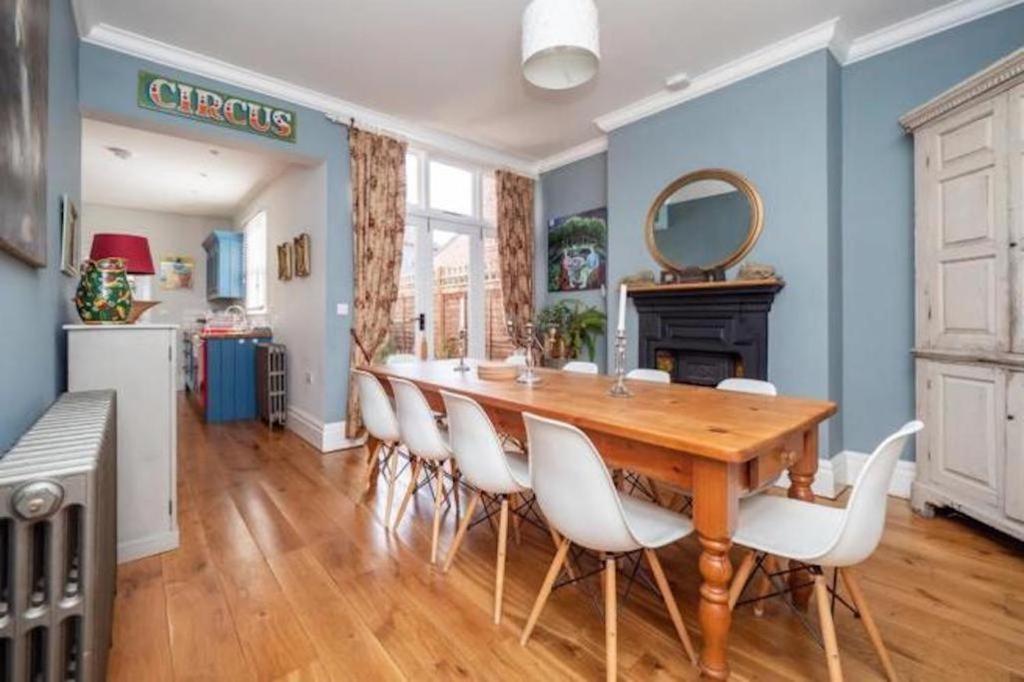 a dining room with a wooden table and white chairs at Seaview Villa - Norfolk Cottage Agency in Sheringham