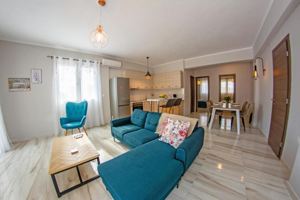 een woonkamer met een blauwe bank en een tafel bij Lydia's Apartments in Mármaron